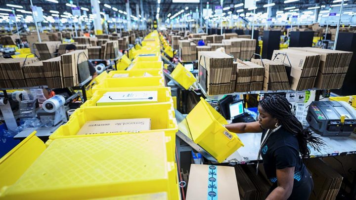 (FILES) In this file photo taken on February 5, 2019 a woman works at a packing station at the 855,000-square-foot Amazon fulfillment center in Staten Island, one of the five boroughs of New York City. - Amazon announced plans July 11, 2019 to offer job training to around one-third of its US workforce to help them gain skills to adapt to new technologies.The US tech giant said it would spend $700 million for its Upskilling 2025 program to train 100,000 employes to help them move into more skilled roles within or outside of Amazon. (Photo by Johannes EISELE / AFP)