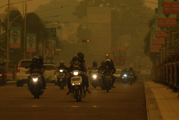 Kabut asap kian pekat di Kota Jambi mengakibatkan jarak pandang jarak pandang hanya mencapai hingga 500 meter, Minggu (22/9/2019). Sinar matahari sulit menembus udara. Suasana siang pun tampak seperti menjelang malam.
