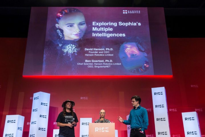 Chief scientist of Hanson Robotics, Ben Goertzel (L) and Founder of Hanson Robotics, David Hanson (R) provide a demonstration with 'Sophia the Robot' (C) during a discussion about Sophia's multiple intelligences and artificial intelligence (AI) at the RISE Technology Conference in Hong Kong on July 10, 2018. / AFP PHOTO / ISAAC LAWRENCE