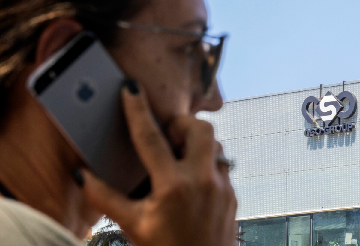 (FILES) In this file photo taken on August 28, 2016 an Israeli woman uses her iPhone in front of the building housing the Israeli NSO group, in Herzliya, near Tel Aviv. - WhatsApp on October 29, 2019 sued Israeli technology firm NSO Group, accusing it of using the Facebook-owned messaging service to conduct cyberespionage on journalists, human rights activists and others. The suit filed in a California federal court contended that NSO Group tried to infect approximately 1,400 